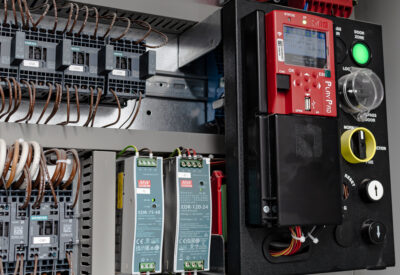 Close-up of electrical control panel featuring circuit breakers and a digital display unit.