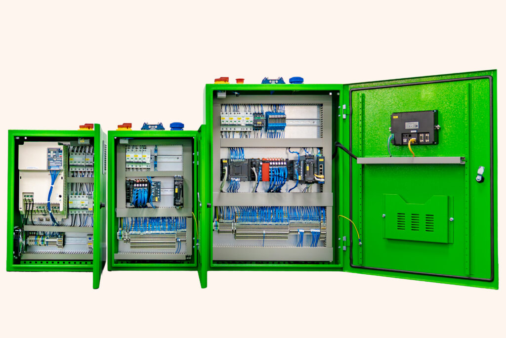 Three green electrical control cabinets with open doors, revealing complex wiring and components inside.