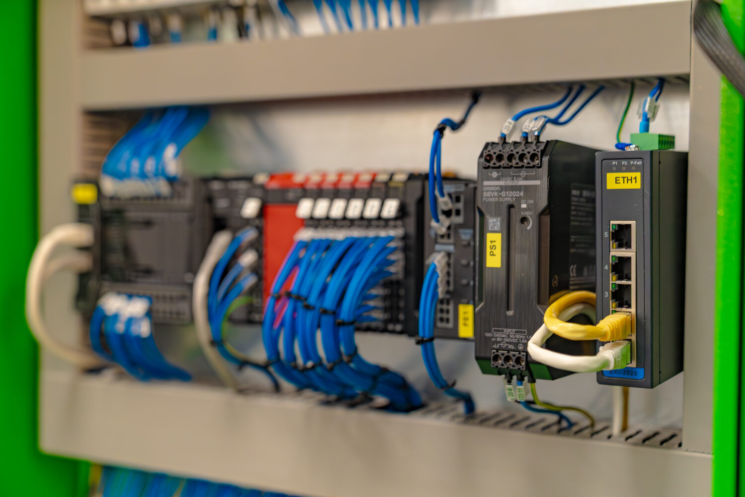A close-up of a control panel featuring various electrical components and connected cables.