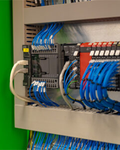Close-up of a control panel with numerous blue and grey cables connected to various components.