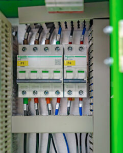 Electrical control panel featuring circuit breakers and labelled wiring connections.